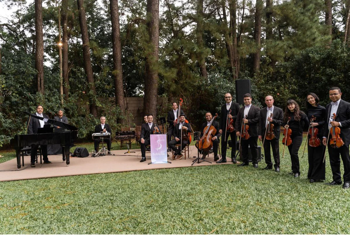 Formação completa da Orquestra Sublime em um jardim